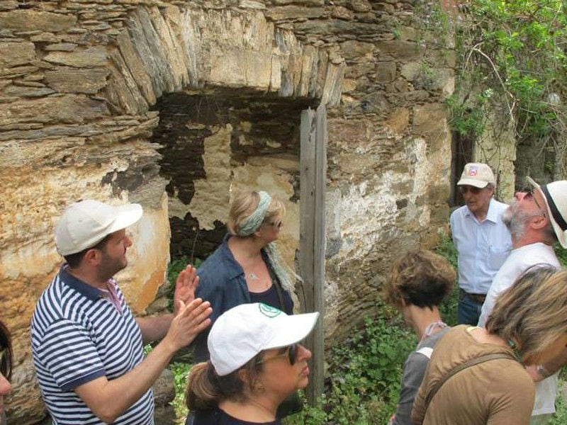 tourists in front of an old stone ruined house in nature around 'Aristaios' farm